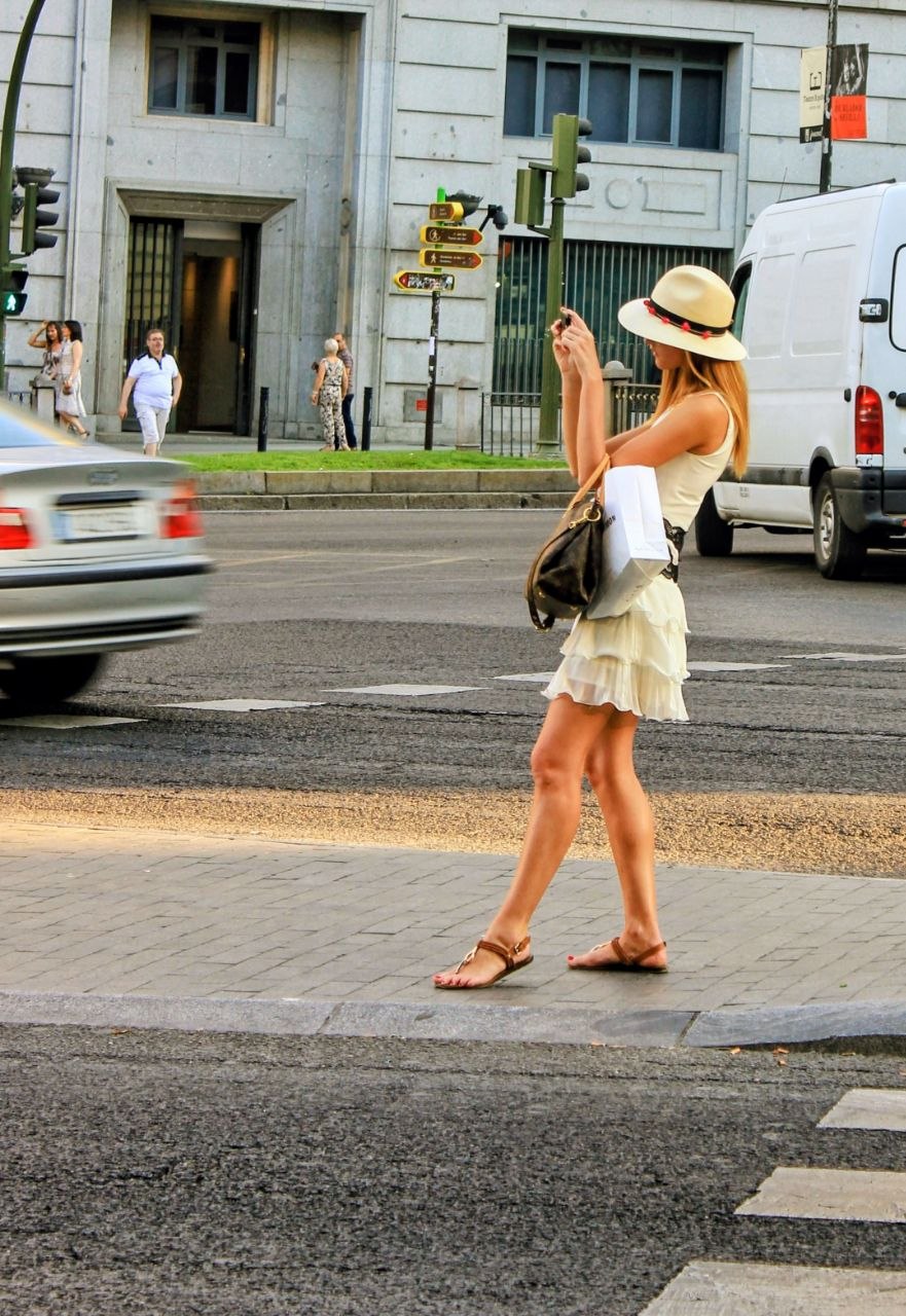Retrato de turista vestida de color sobre la Gran Vía de Madrid